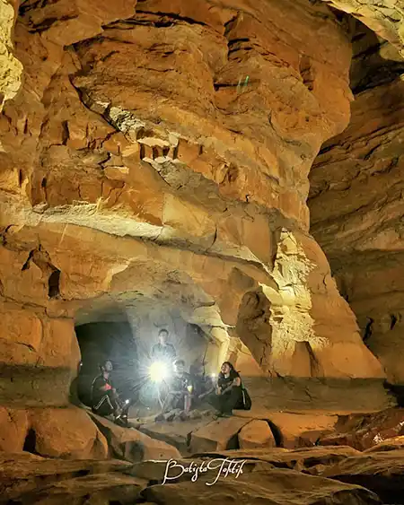 a group of people sitting in krem mawpun cave in mawlyngbna meghalaya