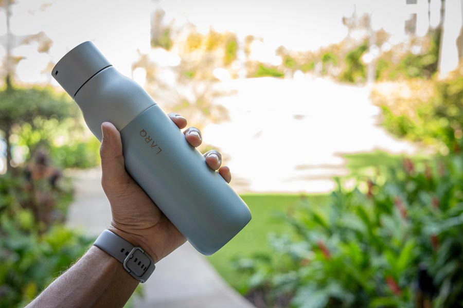 A man holding Larq Filter Water Bottle - travel essentials checklist