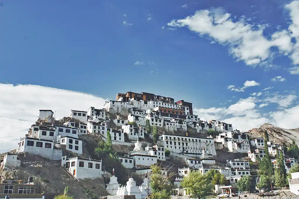 a white buildings on a hill of Thikse Monastery in the background in leh ladakh India