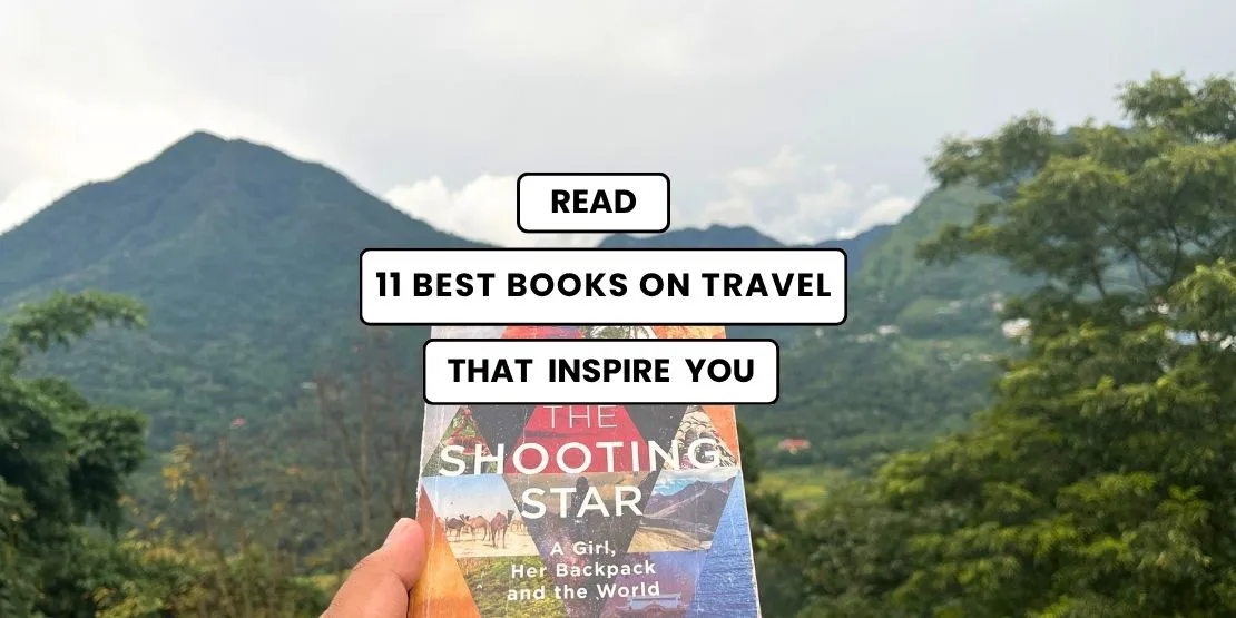 11 Best Travel Books to Read That Inspired Me . The Gypsy Chiring hoding the Shooting Star book in the background of the hilss in Jakhama in Nagaland Northeast India