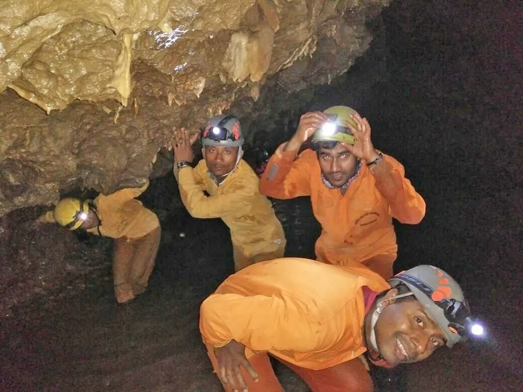 Bending over ducking the rocky surface in Krem Mawmluh Cave in Cherrapunji Meghalaya